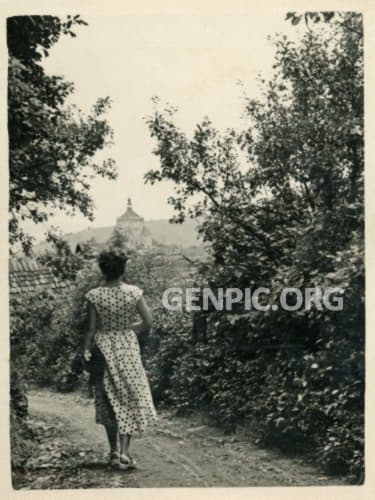 A woman walking through the city. In the background Novy Zamok (New Castle).