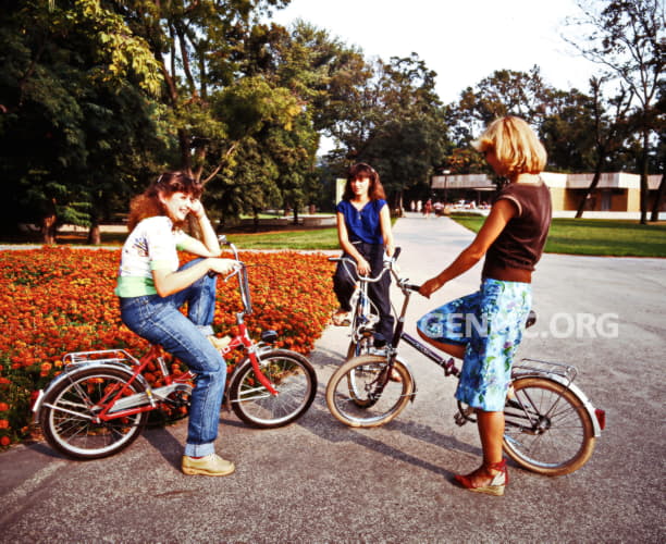 Ladies posing on bicycles.